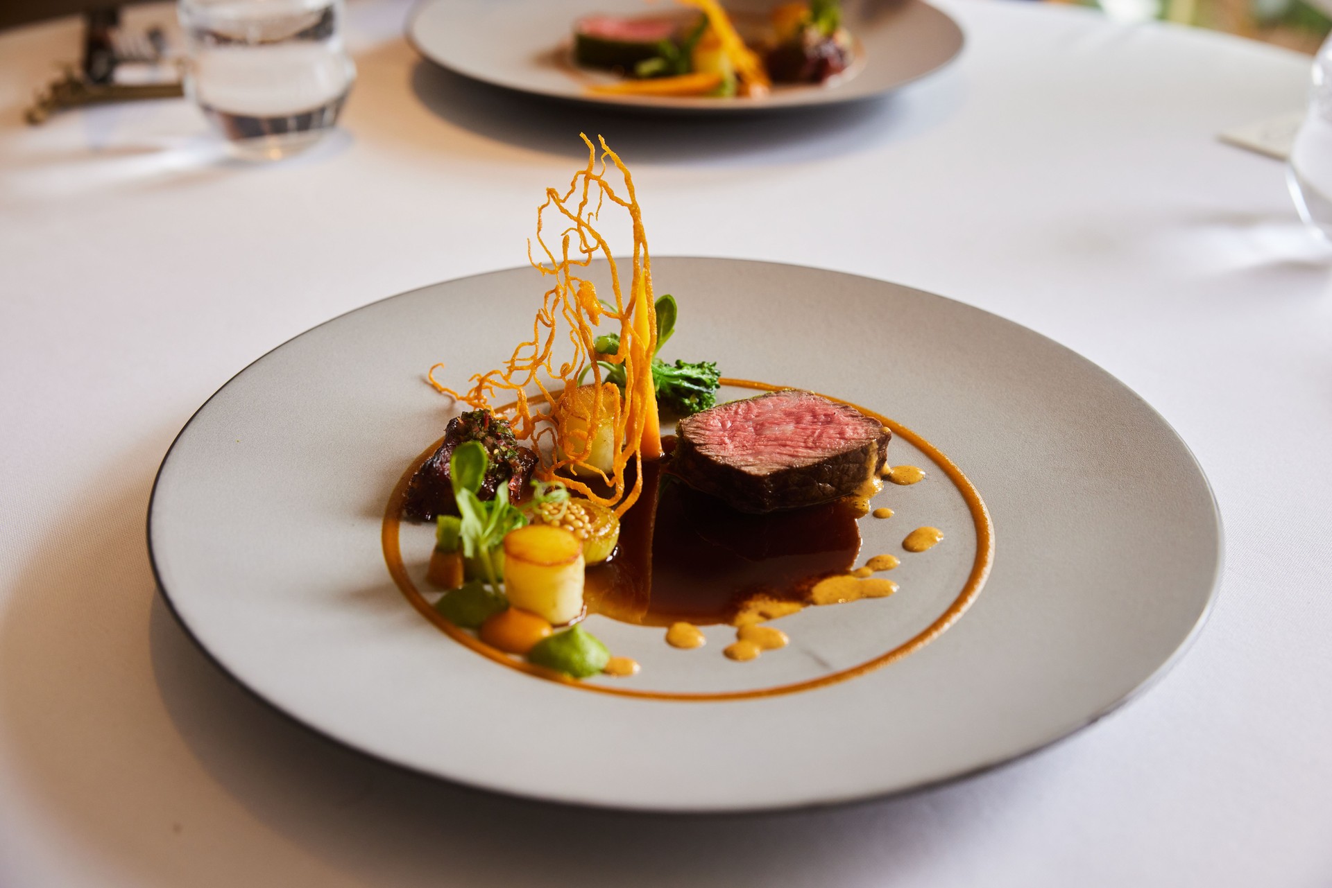 Main dish of beef on a table in an elegant fine dining restaurant